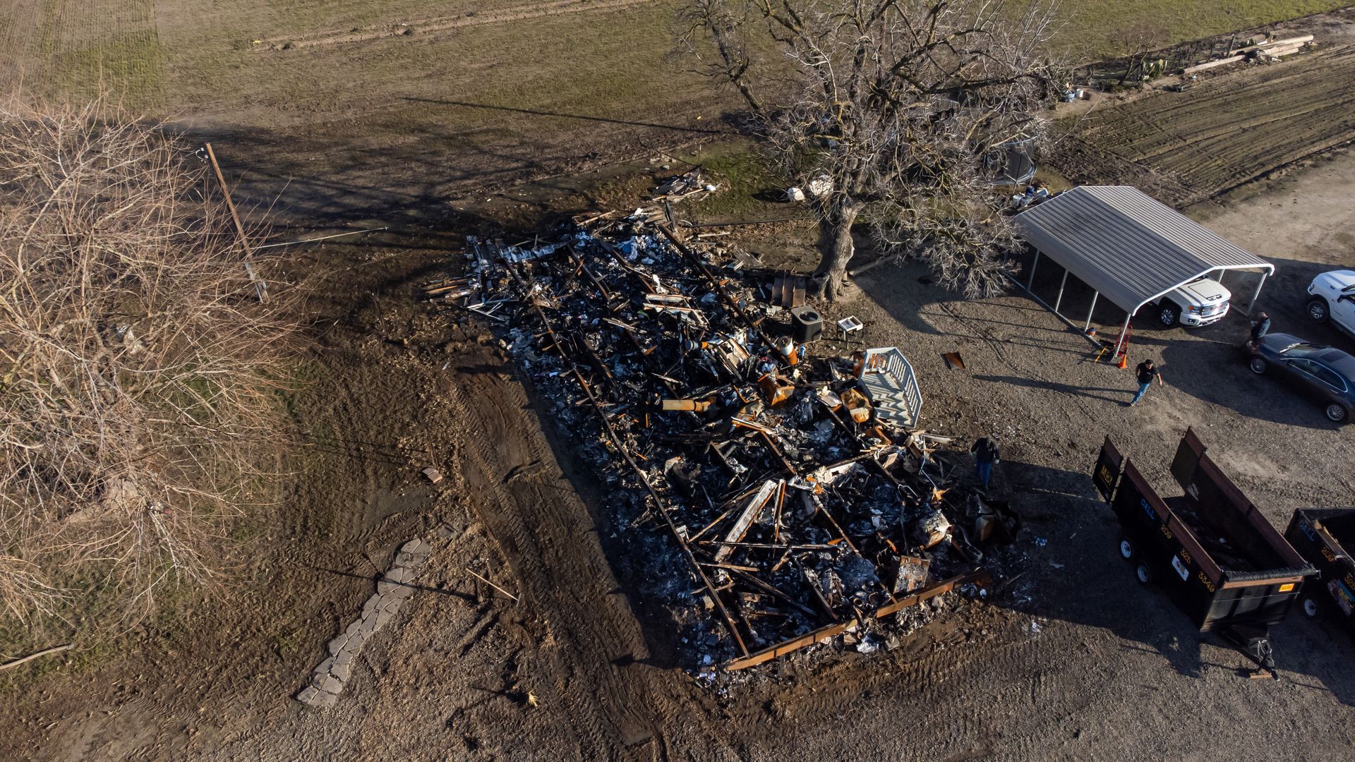 An aerial view of a large pile of trash in a field.
