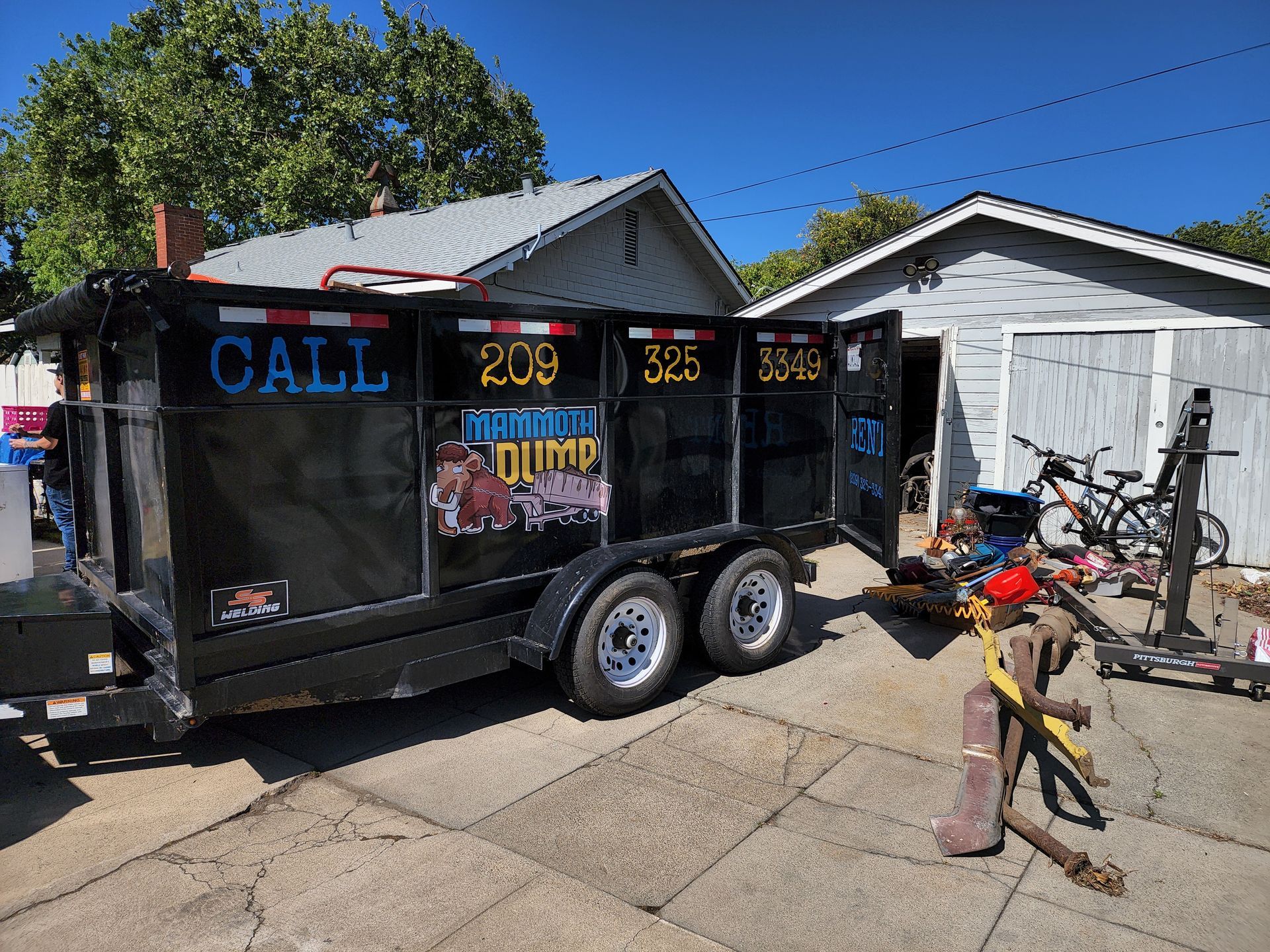 A dumpster trailer is parked in front of a house.