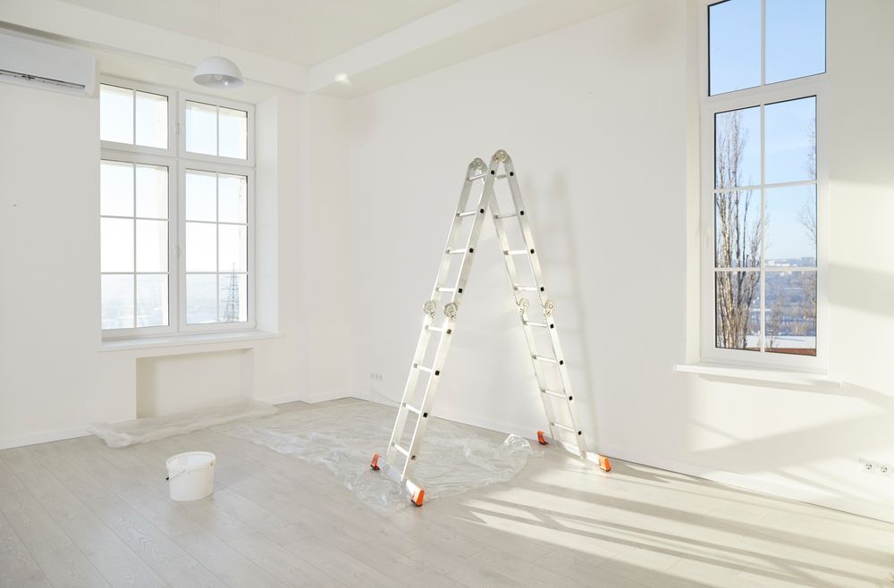 An empty room with a ladder in the middle of it.