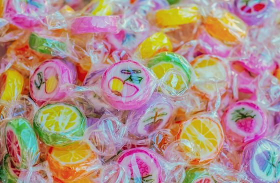 Una vivace collezione di caramelle dure alla frutta, confezionate singolarmente e decorate con colori vivaci.