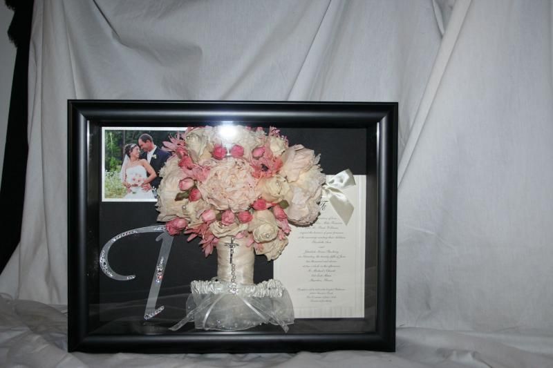 Framed wedding bouquet with pink and cream flowers, ribbon, and photo collage on a white backdrop