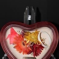 Heart-shaped red box with colorful dried flowers on a dark background