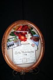 Oval framed “Happy Anniversary” collage with flowers on a black background