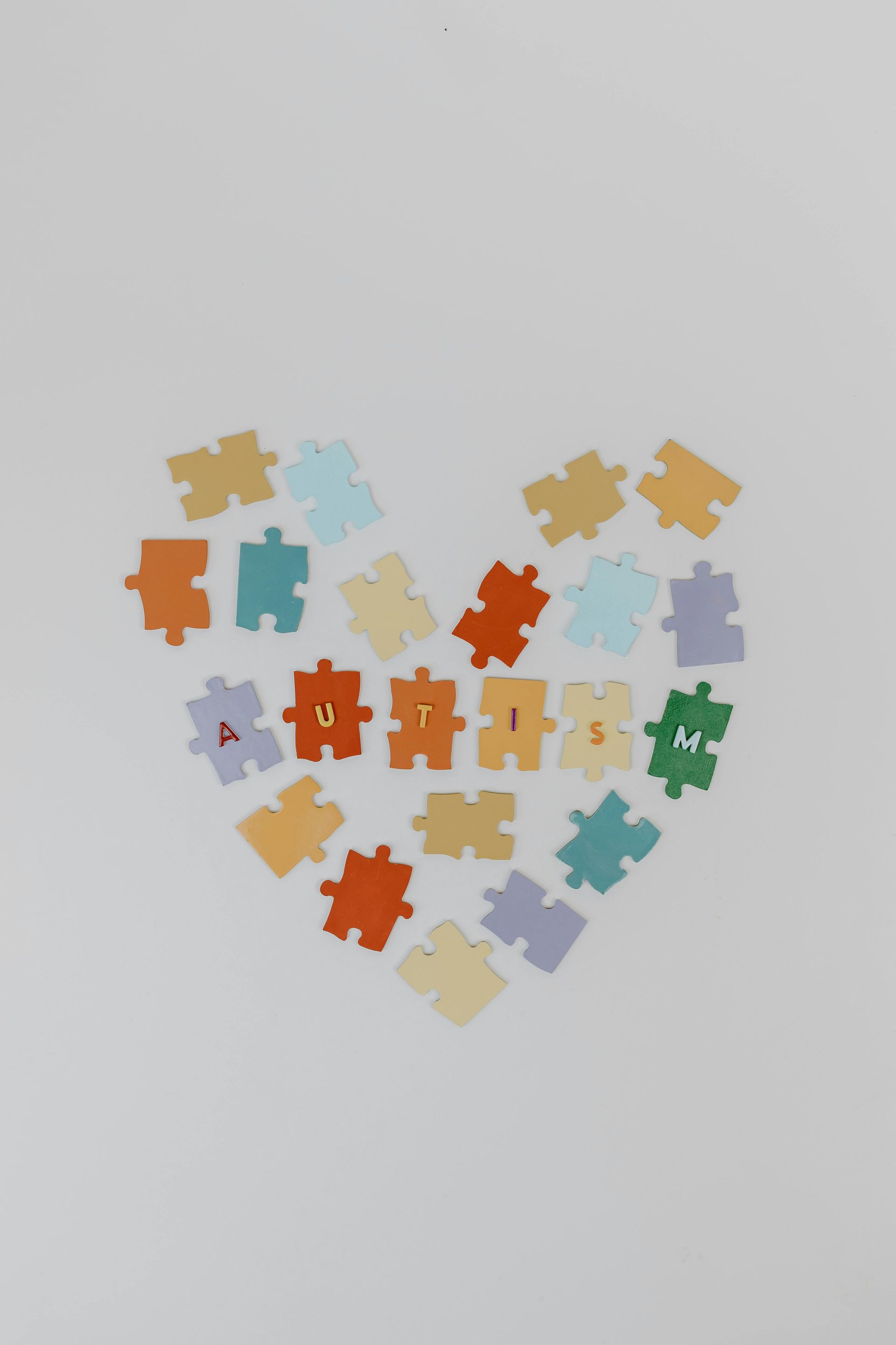 Heart shape made of colorful puzzle pieces, with the word