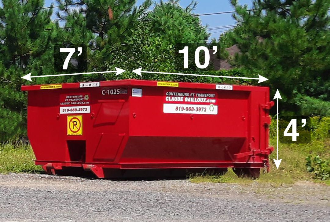 Conteneur à ordures rouge avec des dimensions indiquées 7', 10' et 4' sur le bord d'une route de gravier.