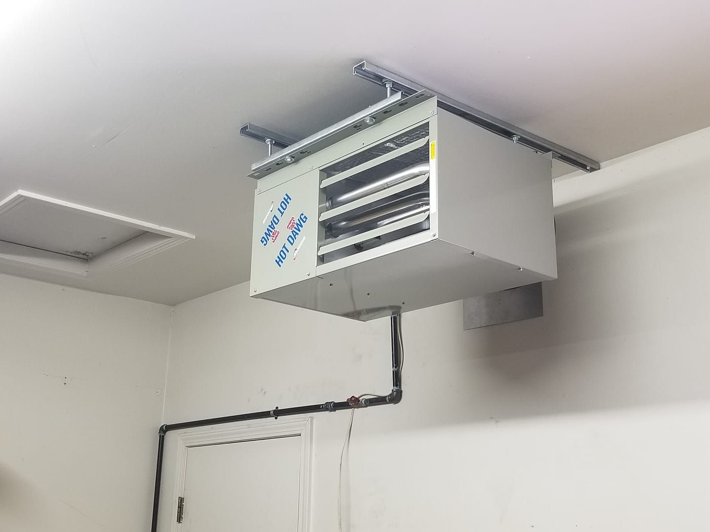 A white box is hanging from the ceiling of a room.