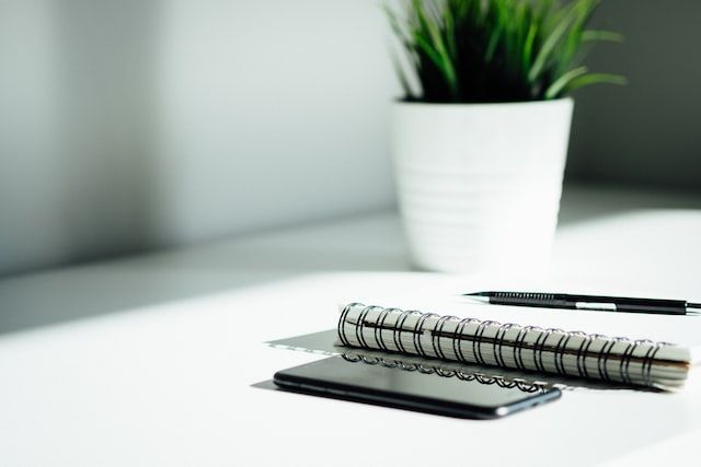Notebook, phone, and workspace representing compassionate cremation services in Biddeford, ME