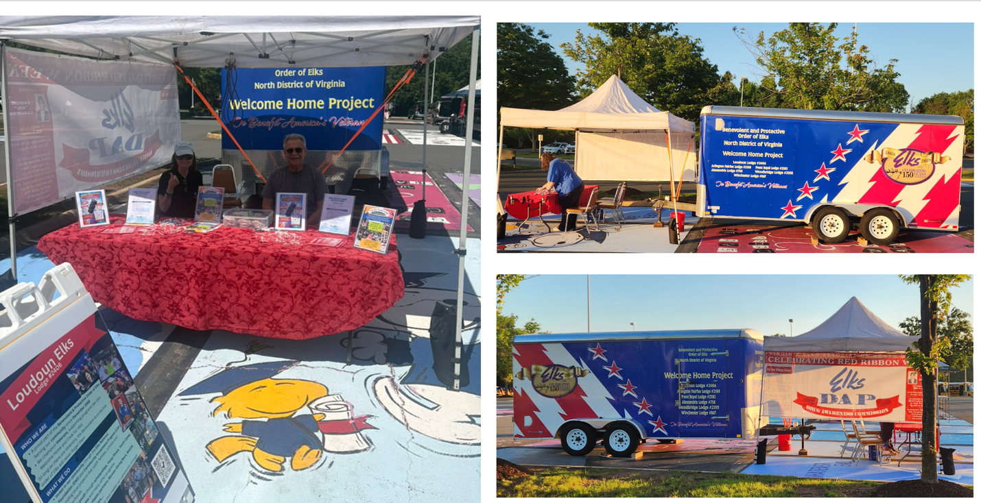 Outdoor event booth with blue banners, red tablecloth, and promotional truck display under tents