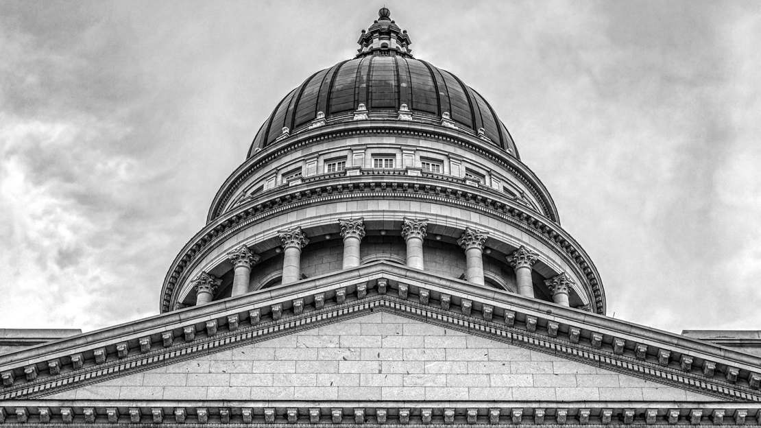 Black-and-white photo of a domed capitol building against a cloudy sky