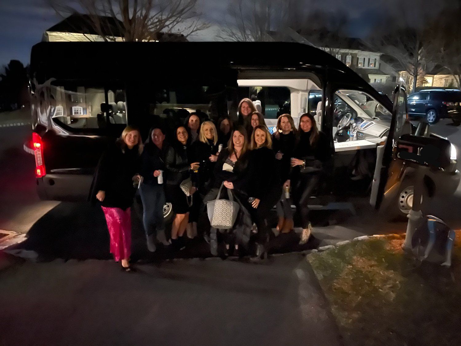 A group of women are posing for a picture in front of a truck.