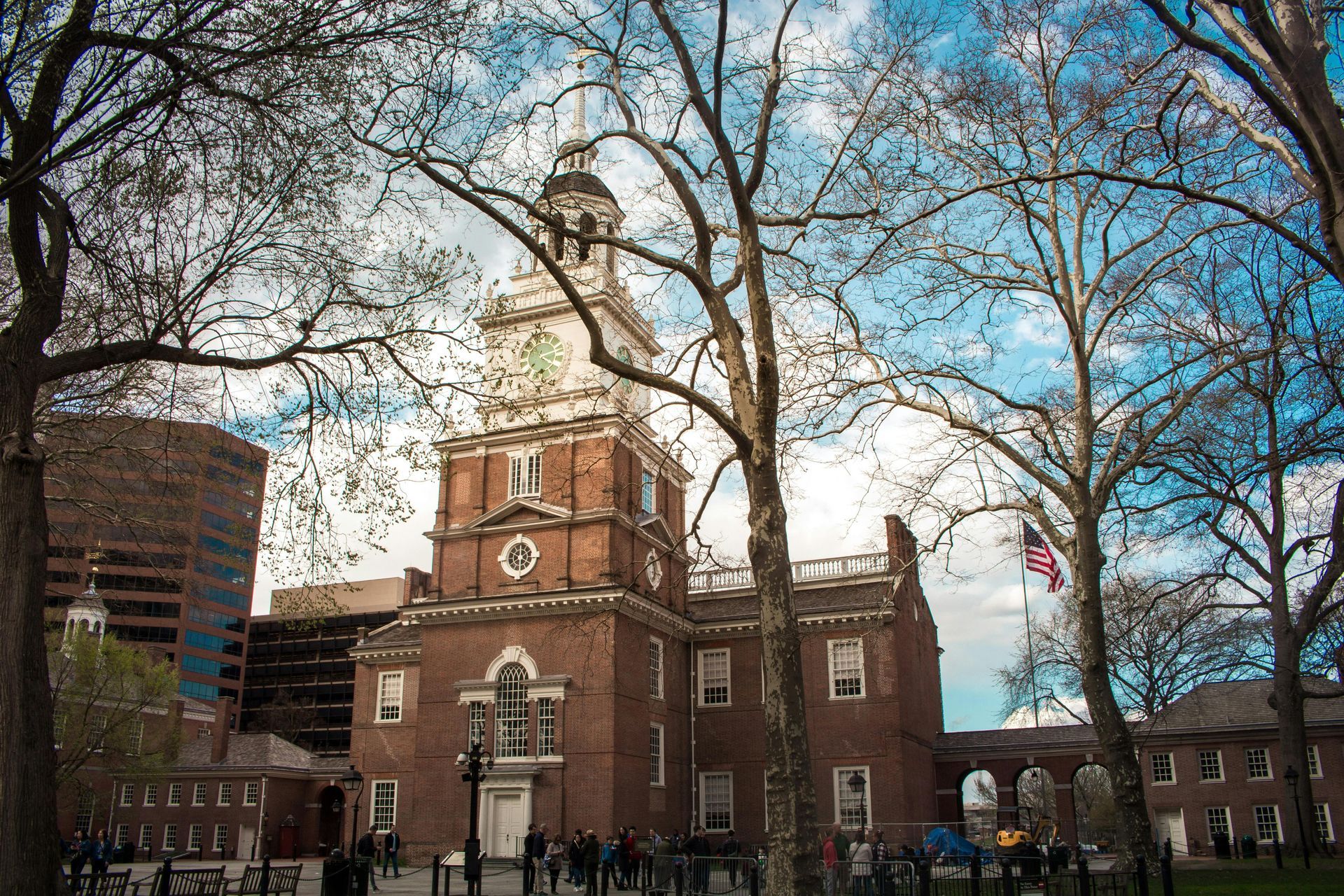 A large brick building with a clock tower in the middle of a park.