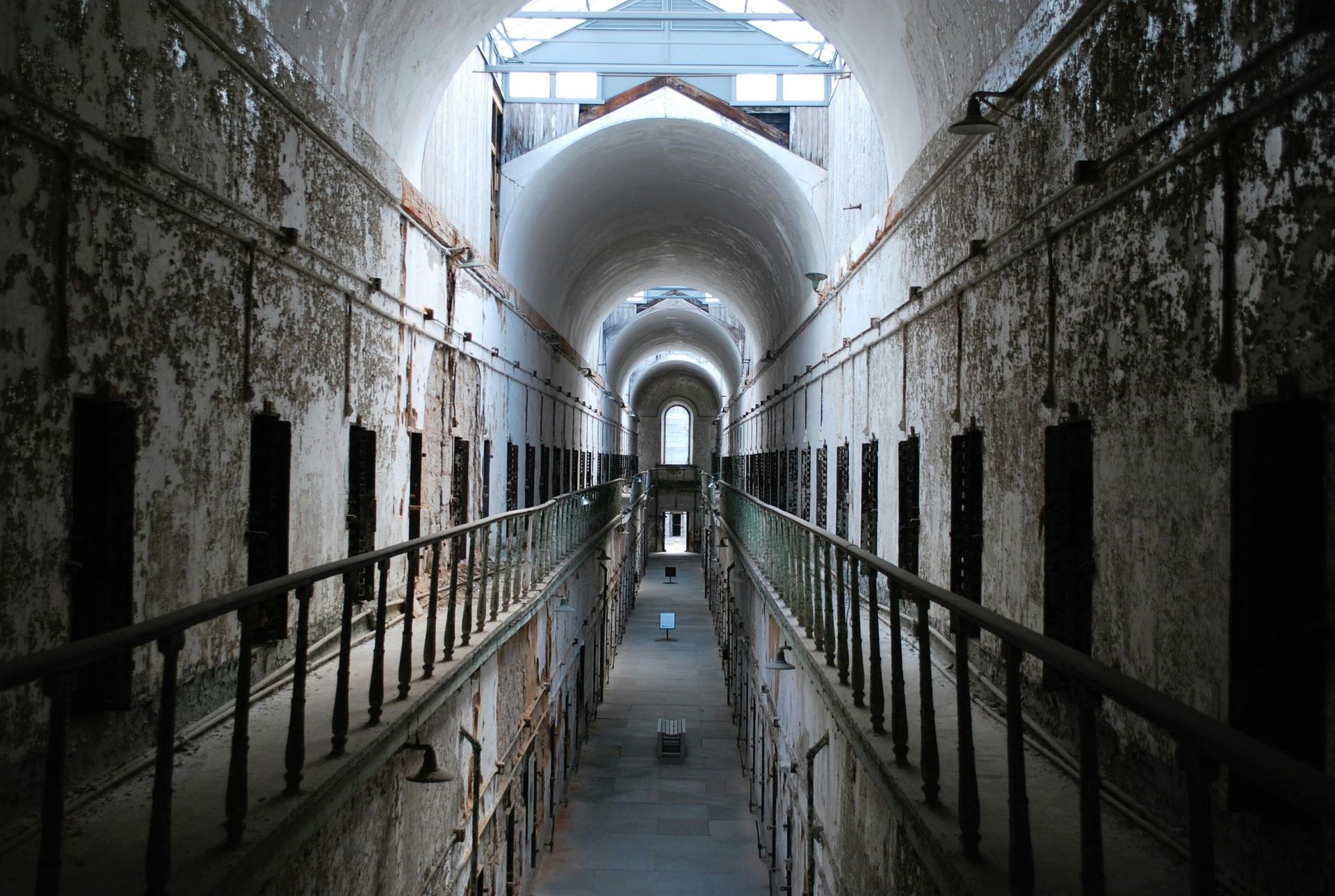 A very long hallway in an old building with a lot of windows.