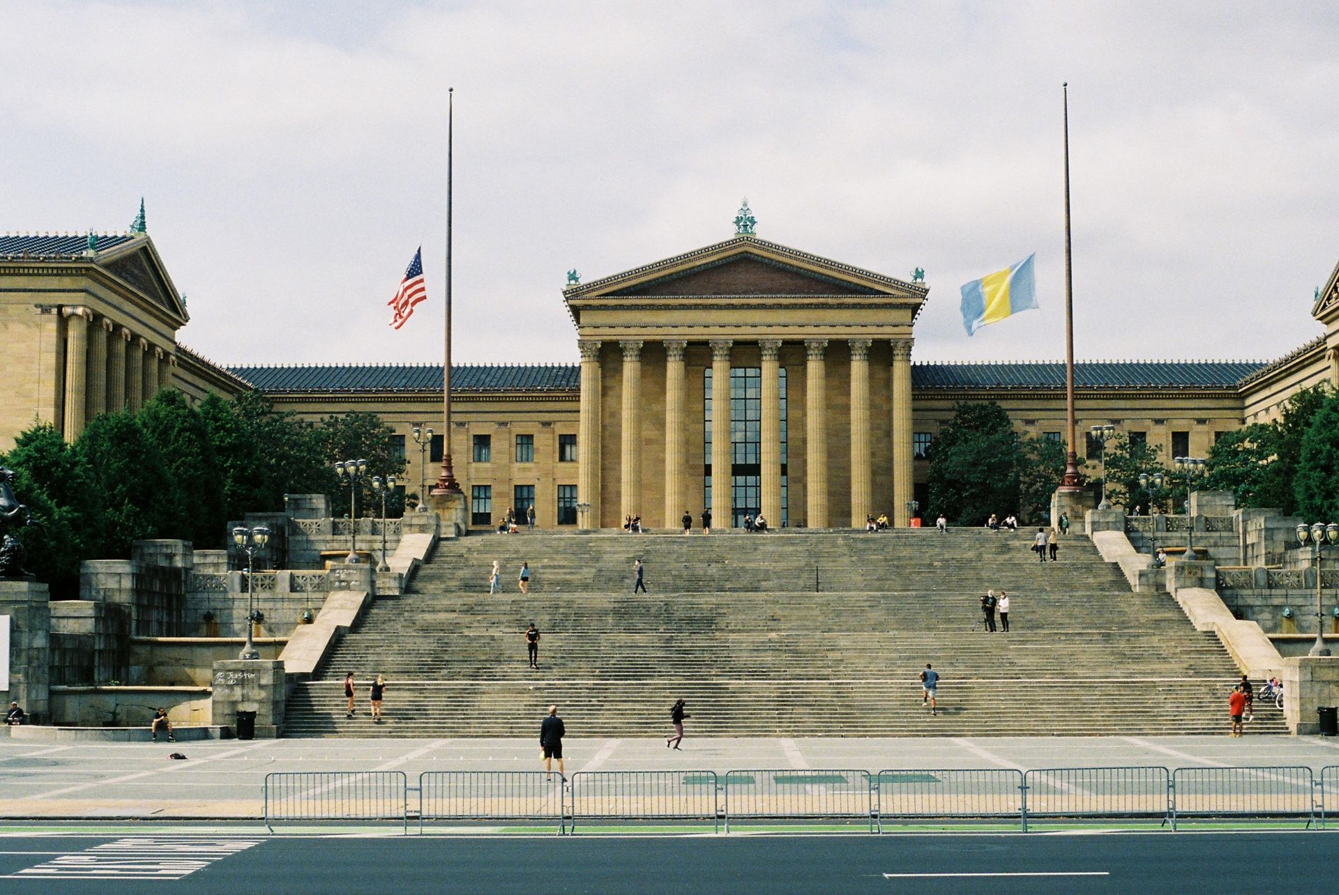A large building with stairs and flags in front of it