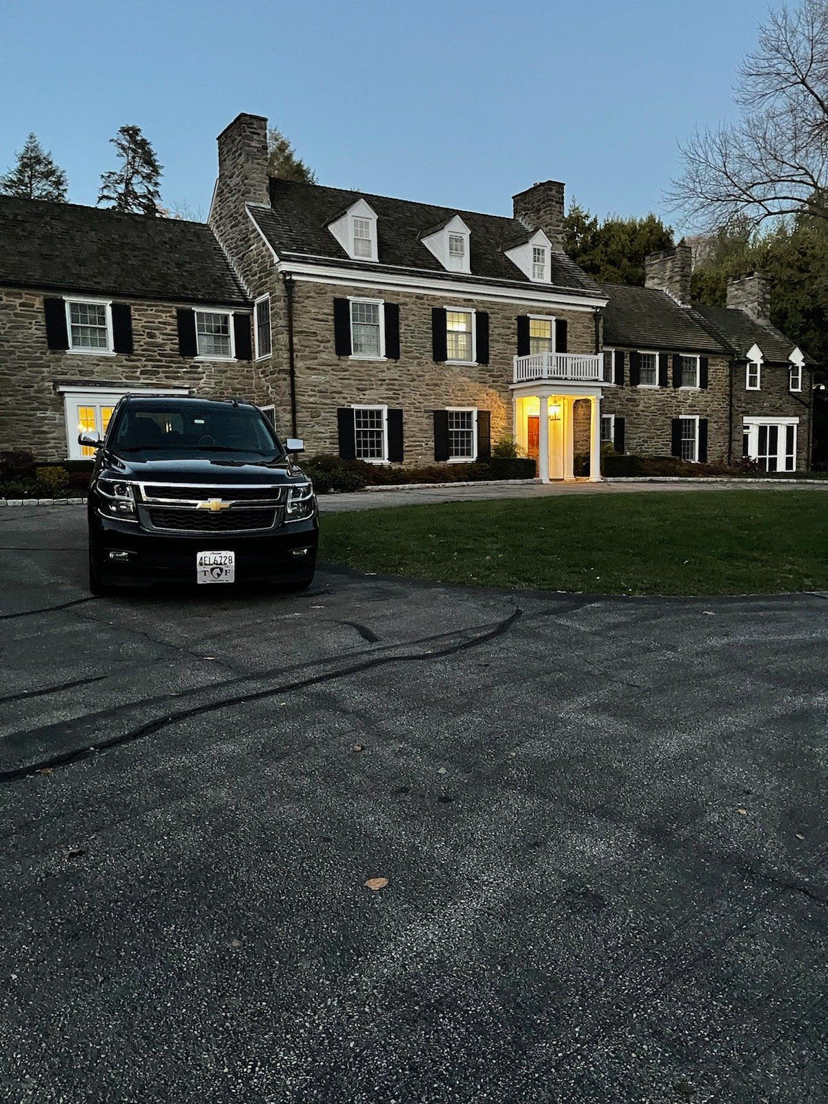A black suv is parked in front of a large stone building