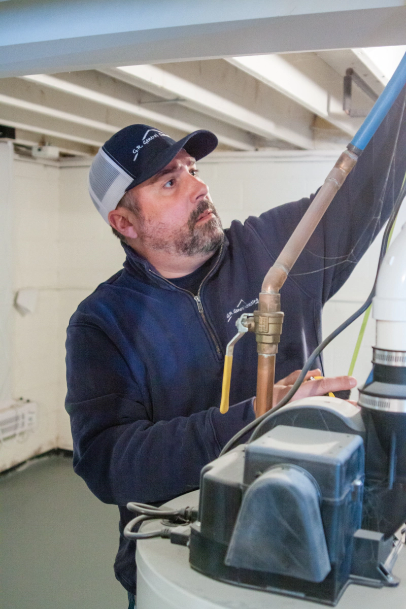 Technician inspecting HVAC equipment with a flashlight in a utility room