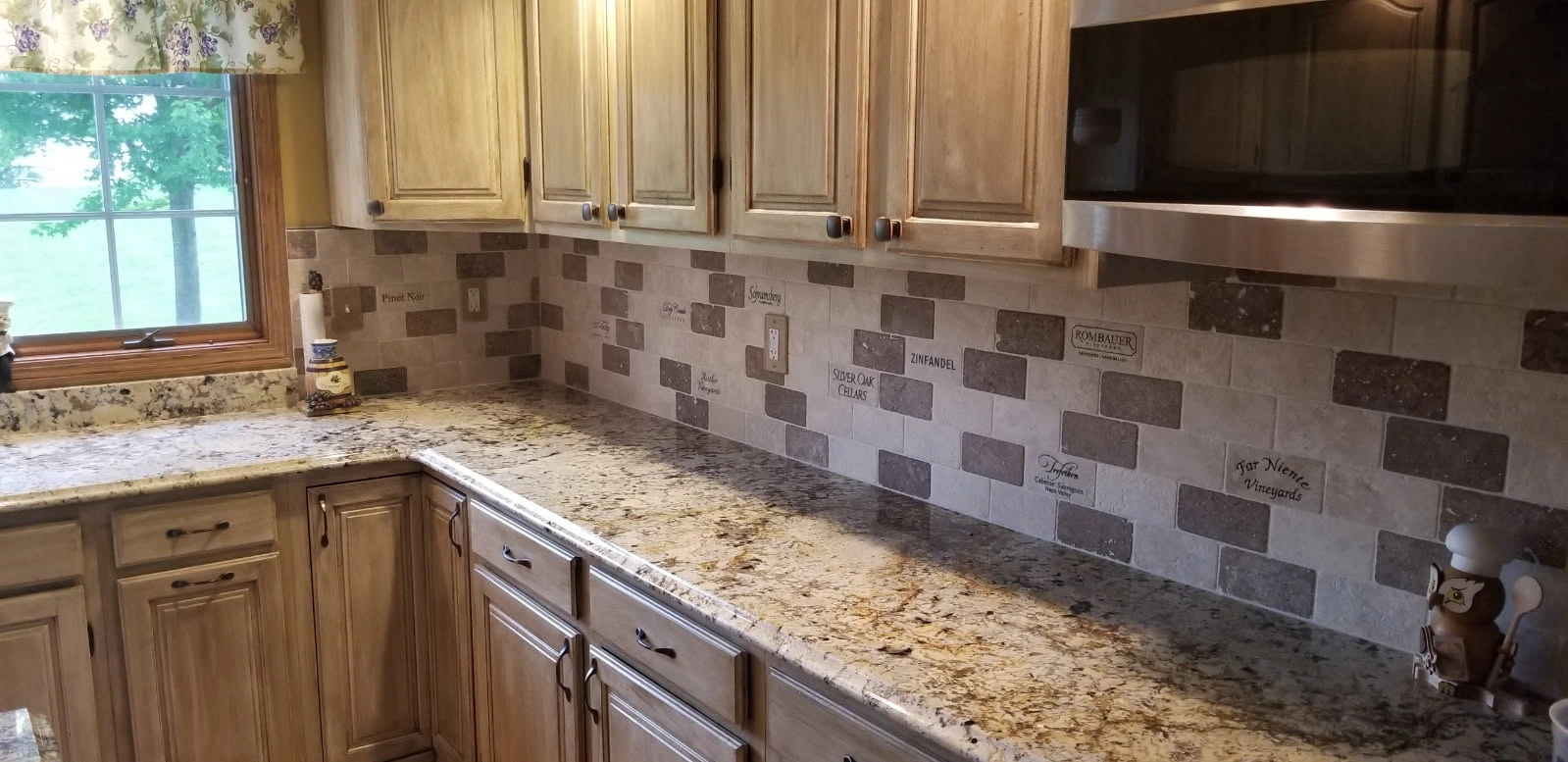 Modern kitchen with wood cabinets, granite countertops, mosaic tile backsplash, and stainless steel appliances