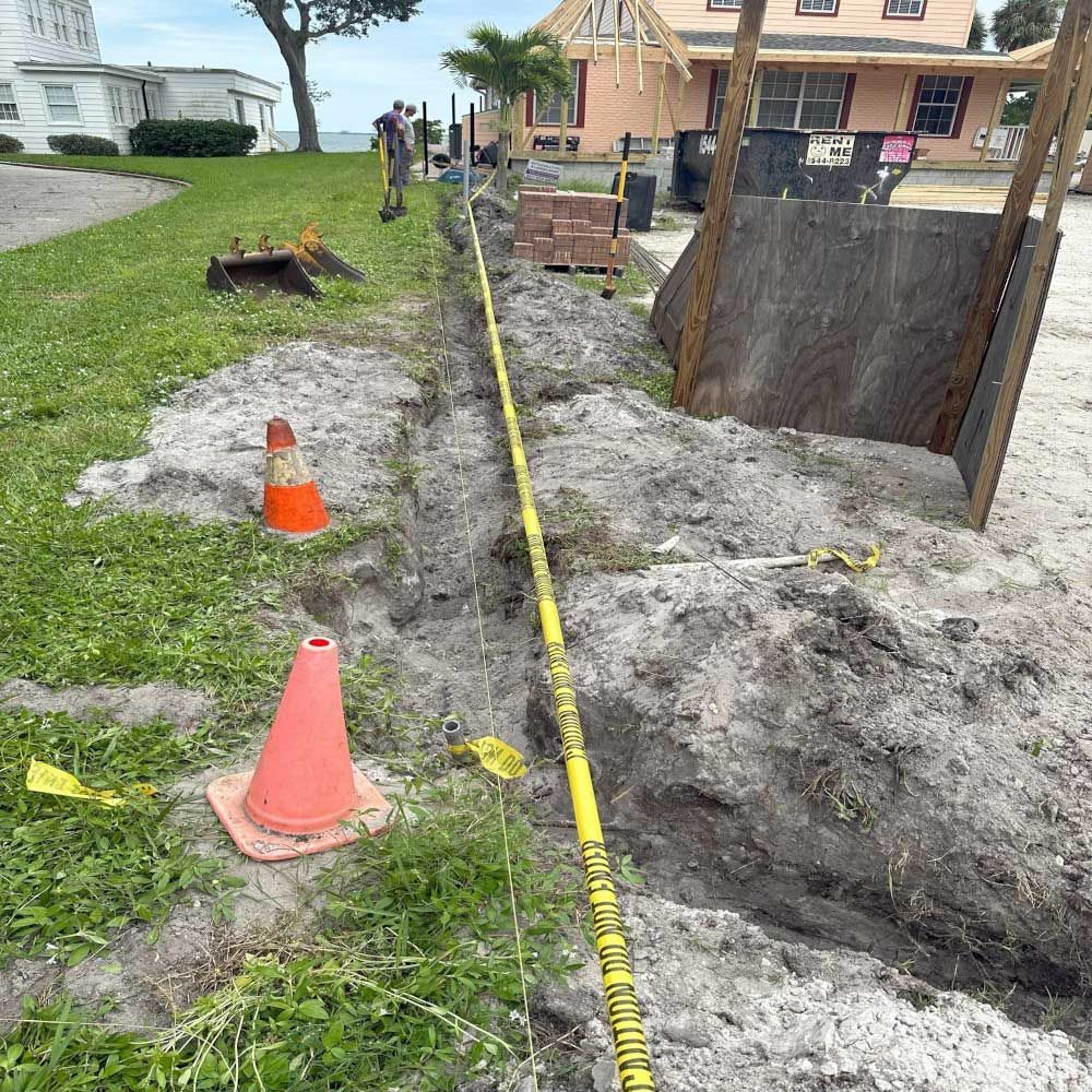 A man is digging a hole in the ground in front of a house.