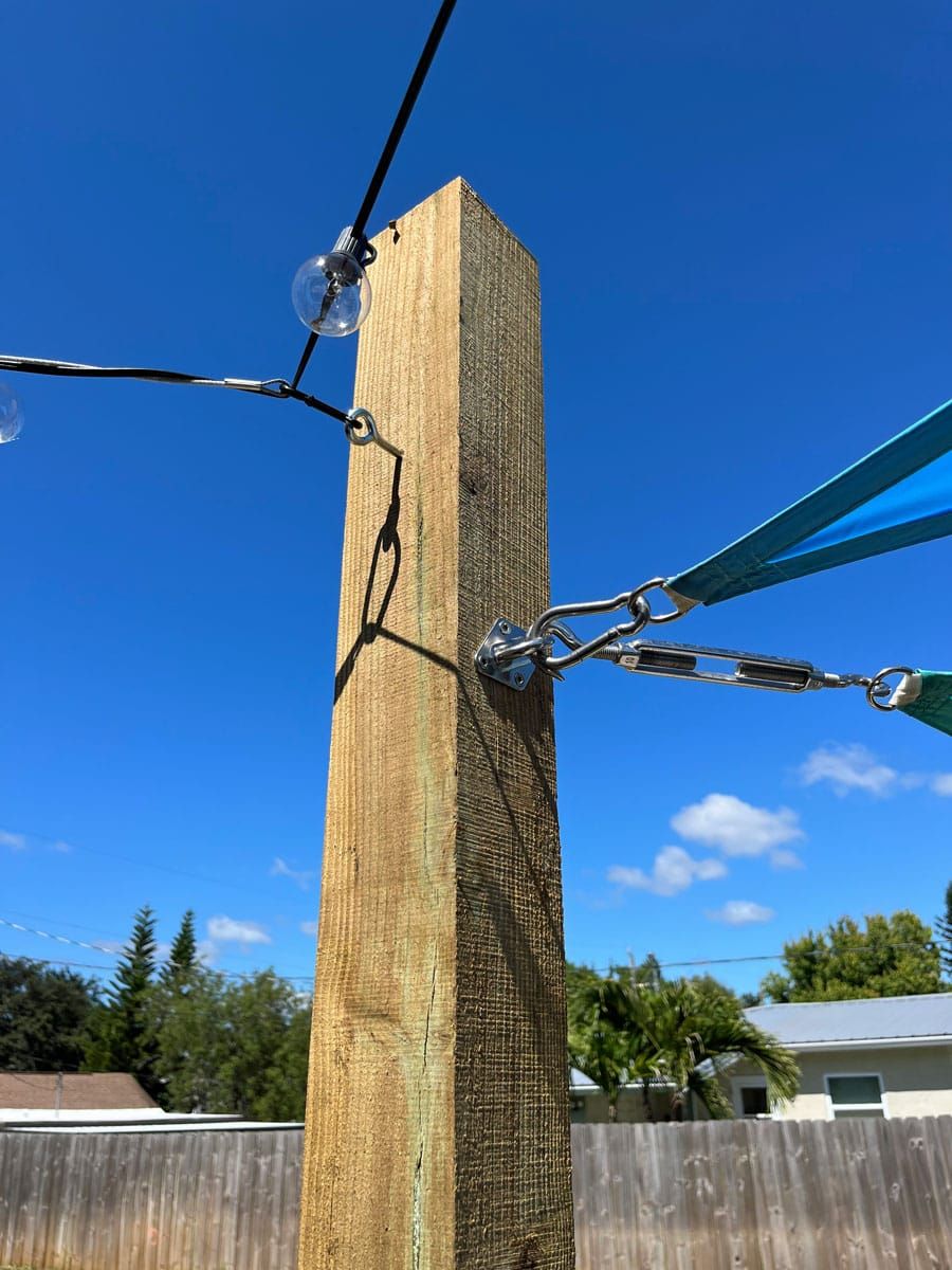 A wooden post with a blue umbrella attached to it