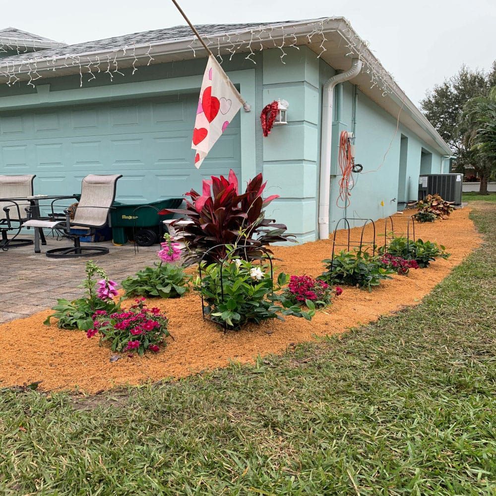 A house with a flag and flowers in front of it