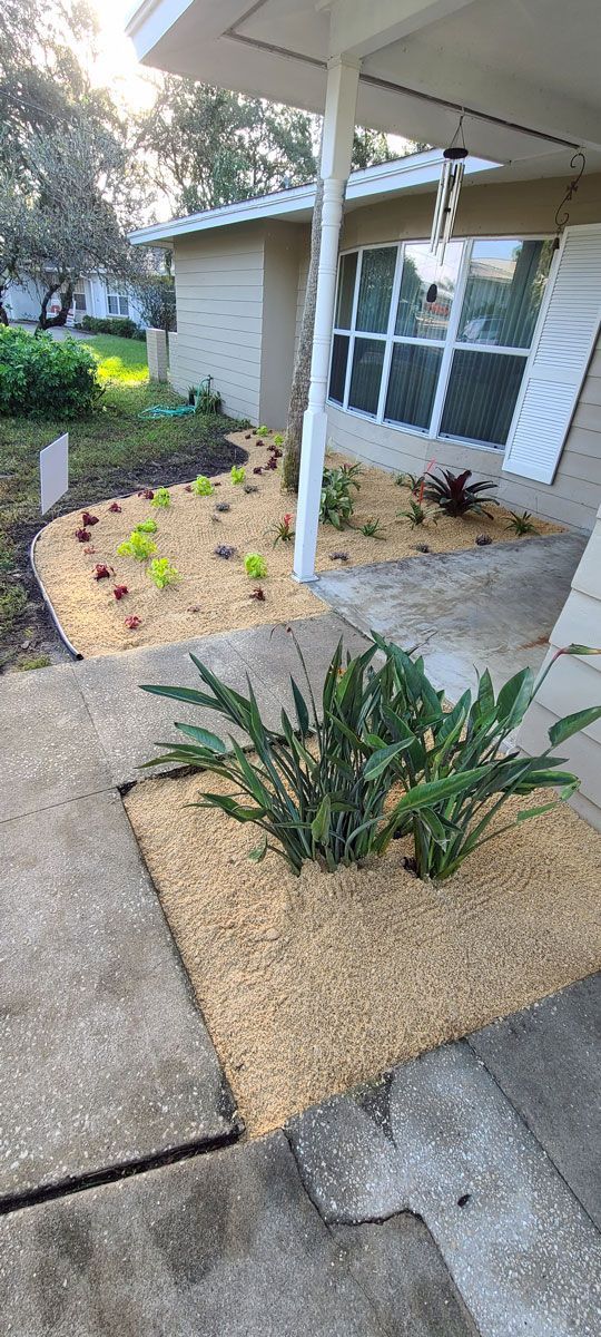 A house with a patio and a garden in front of it.