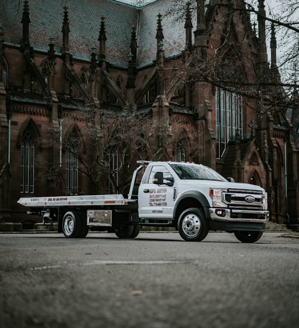 A tow truck is parked in front of a church.