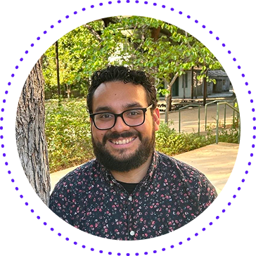 Smiling man with glasses in a floral shirt outdoors, framed by a purple dotted circle.