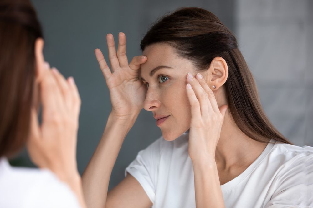 Woman Examining Her Face in A Mirror — Beauty In Profile In Salamander Bay, NSW