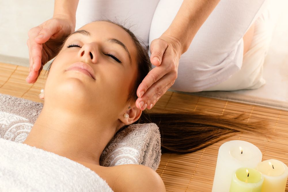 Woman Receiving a Reiki Treatment with Hands Over Her Head — Beauty In Profile In Salamander Bay, NSW