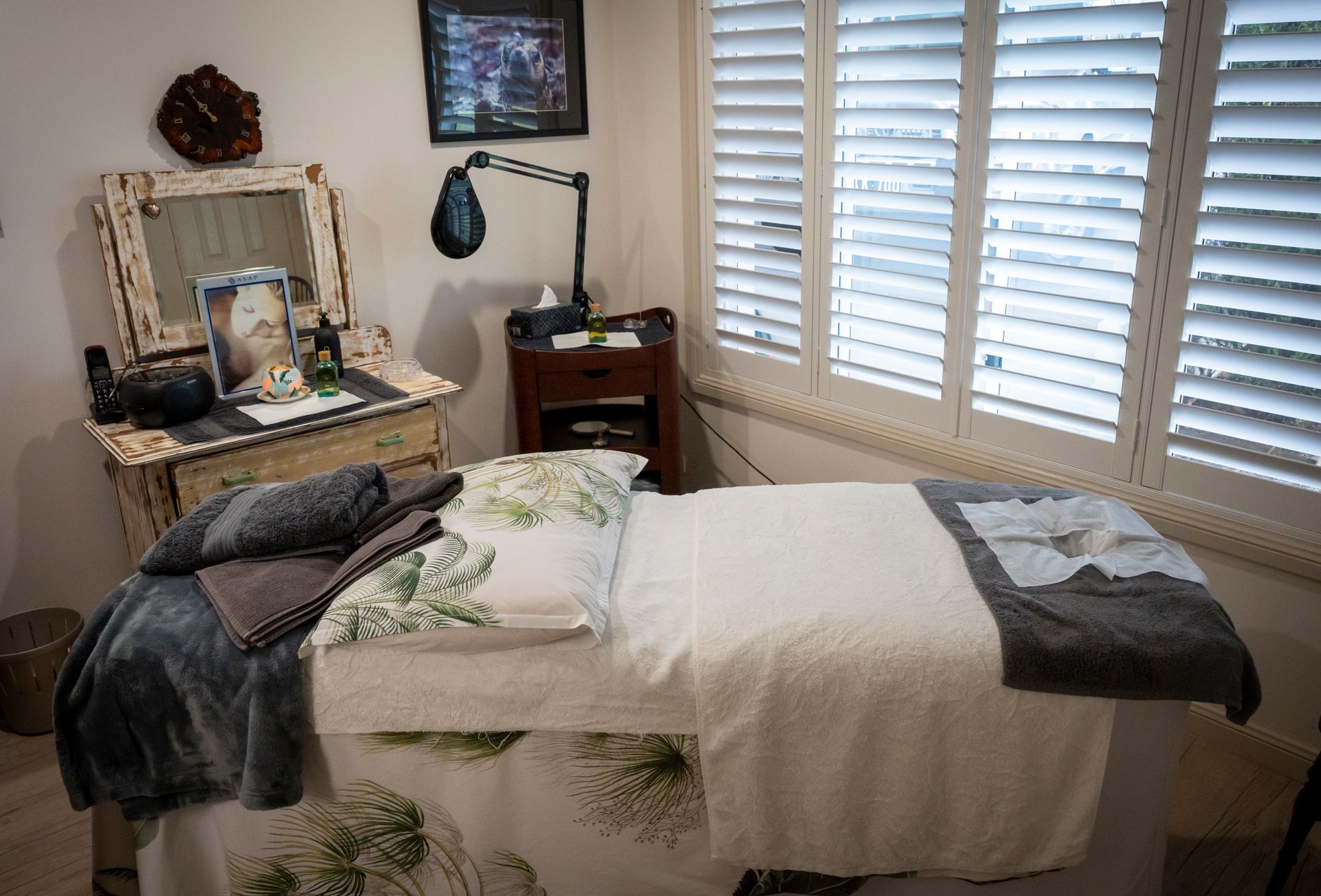 Massage Therapy Room with Massage Table, Shutters, and Decorative Items — Beauty In Profile In Salamander Bay, NSW