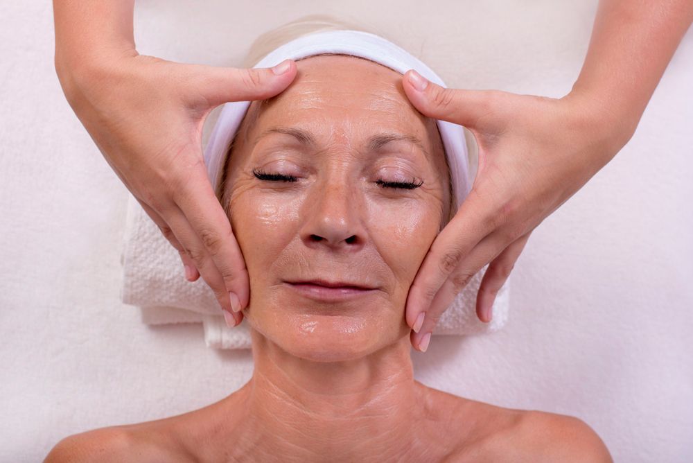 Woman Receiving Facial Massage with Hands on Cheeks — Beauty In Profile In Salamander Bay, NSW