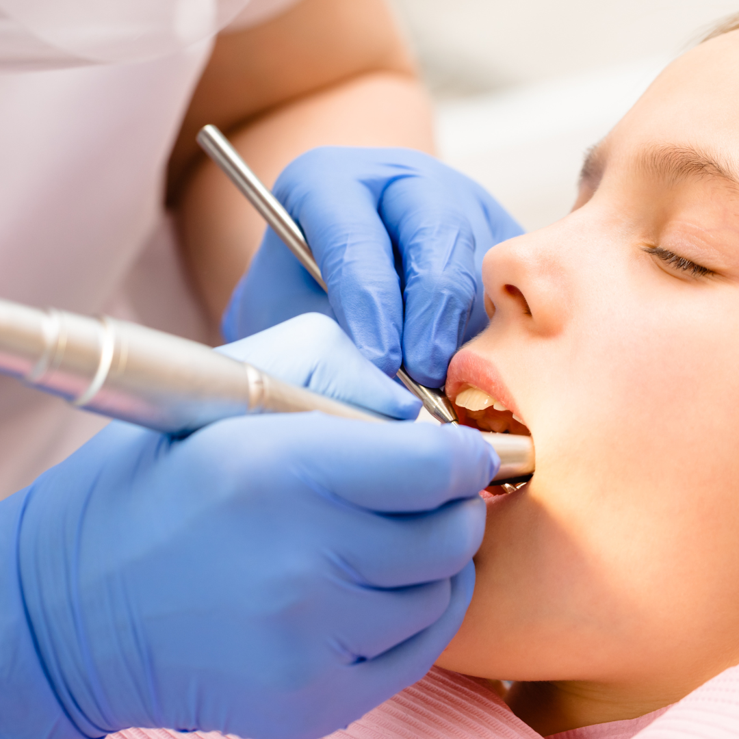 Dentist carrying out hygienist oral hygiene treatment