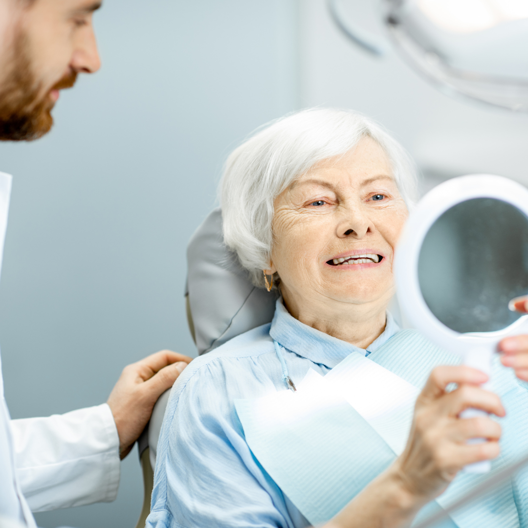 Patient happy with their new dentures looking in mirror