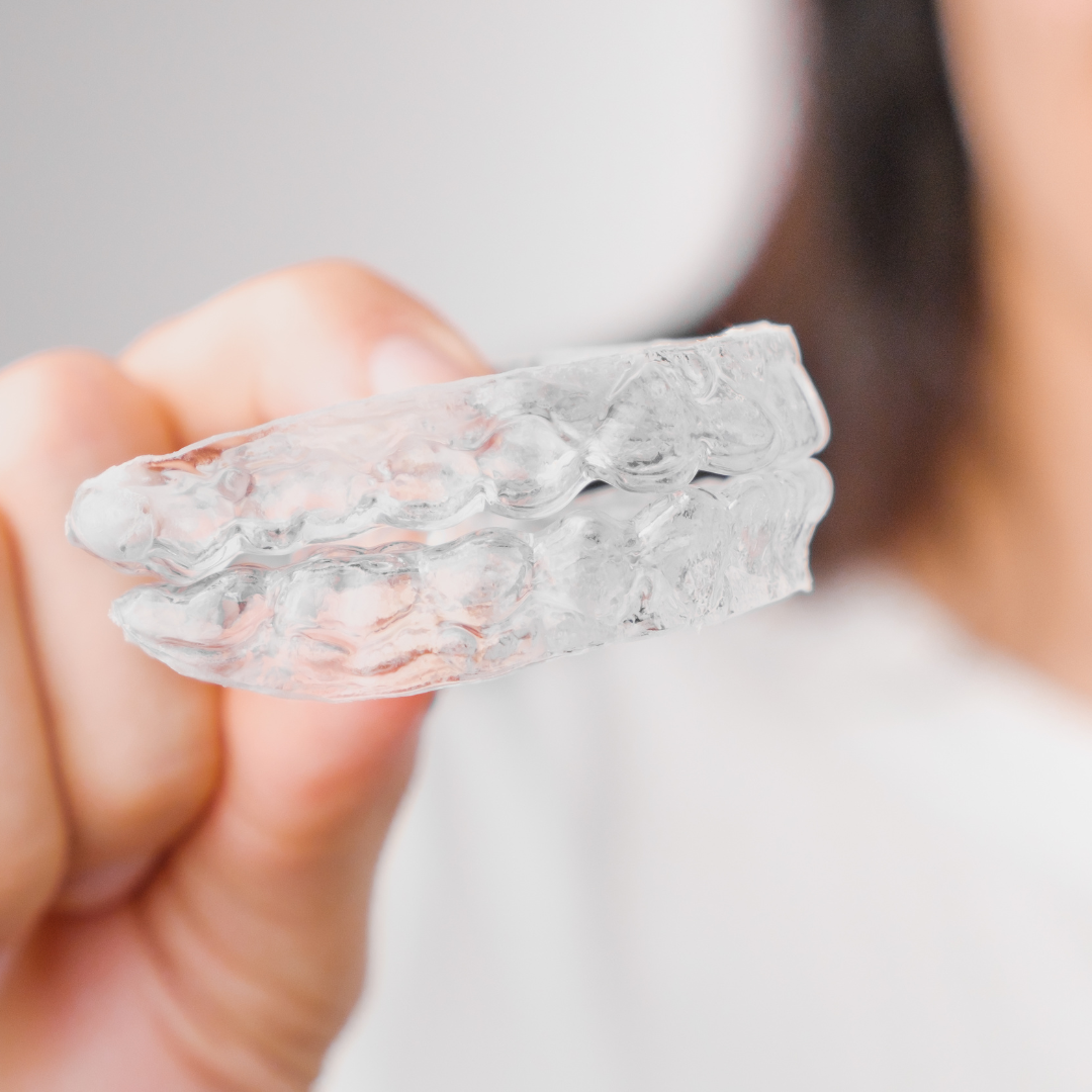 Clear aligner being held by patient orthodontics