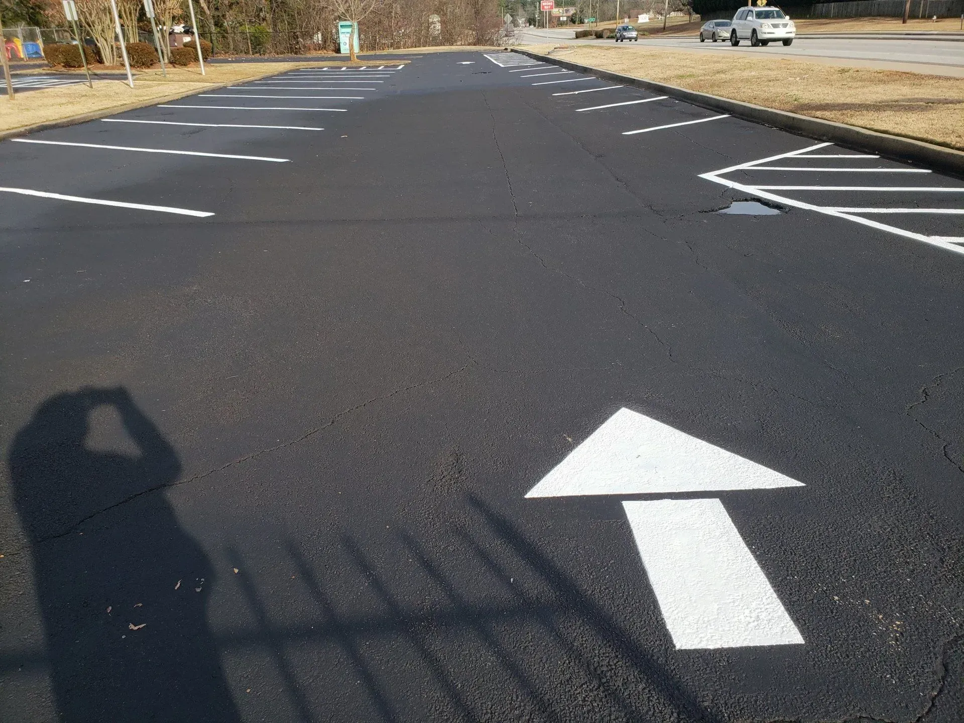 A parking lot with a white arrow pointing to the right