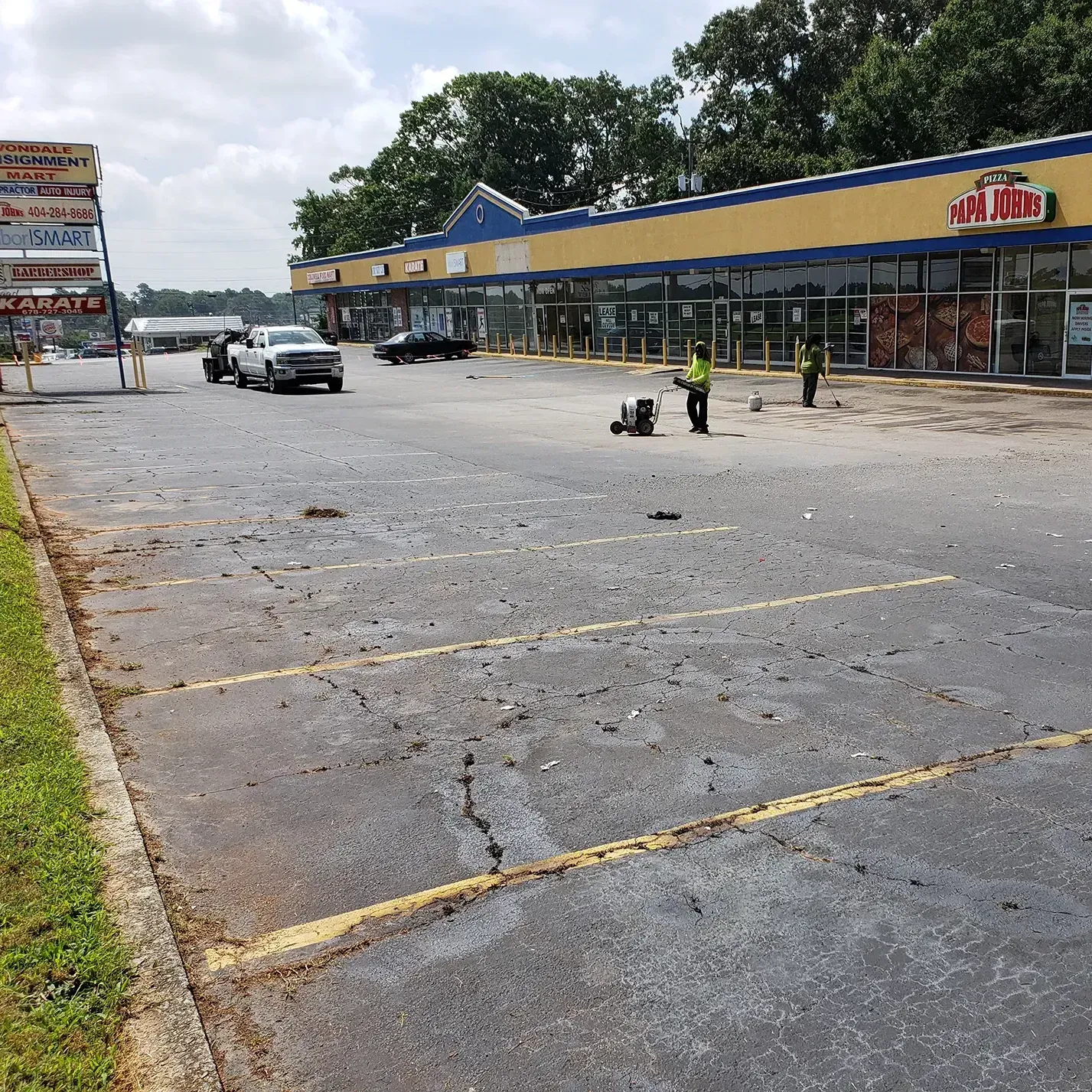 A parking lot with lots of cracks and faded lines