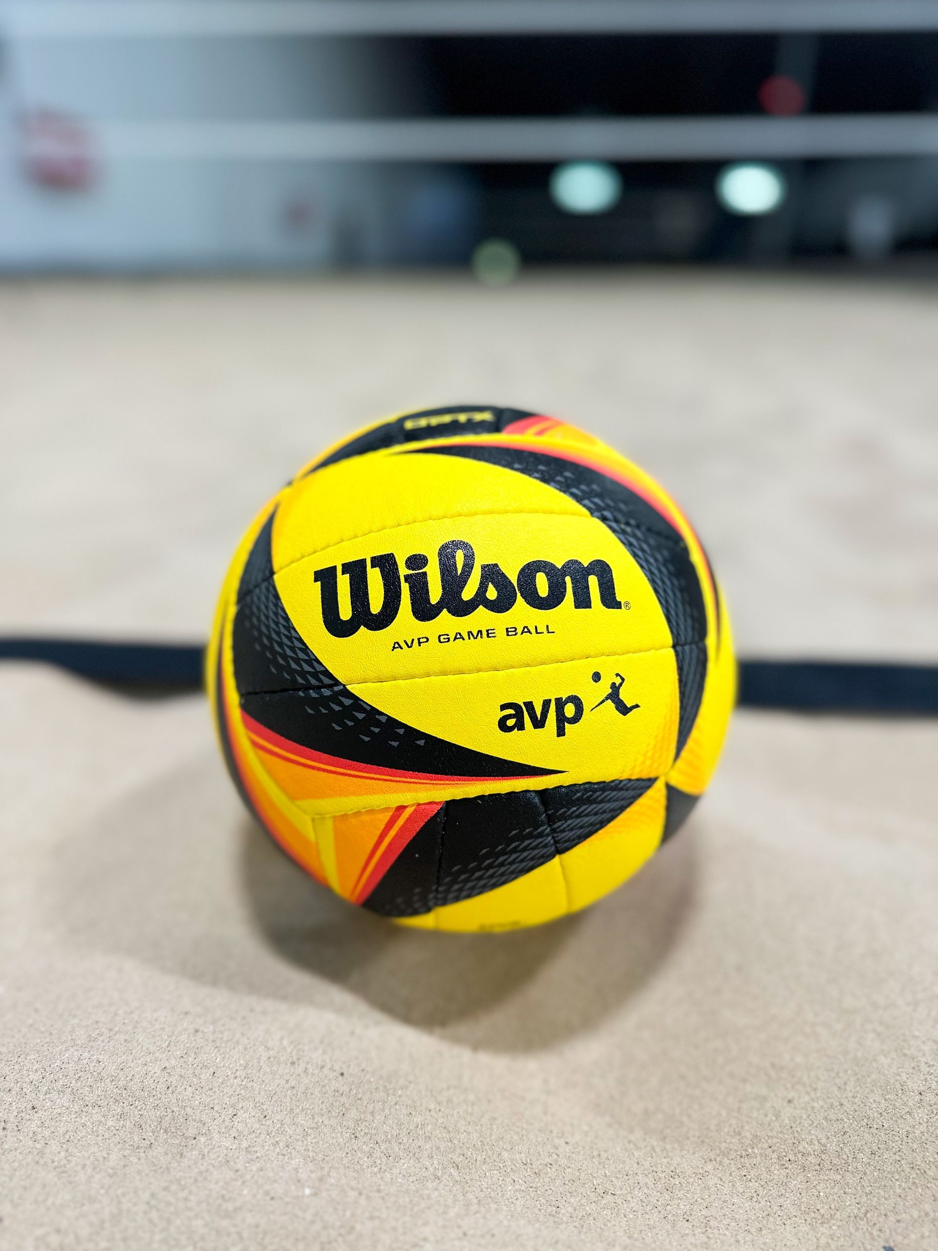 Yellow Wilson AVP volleyball on a sand court
