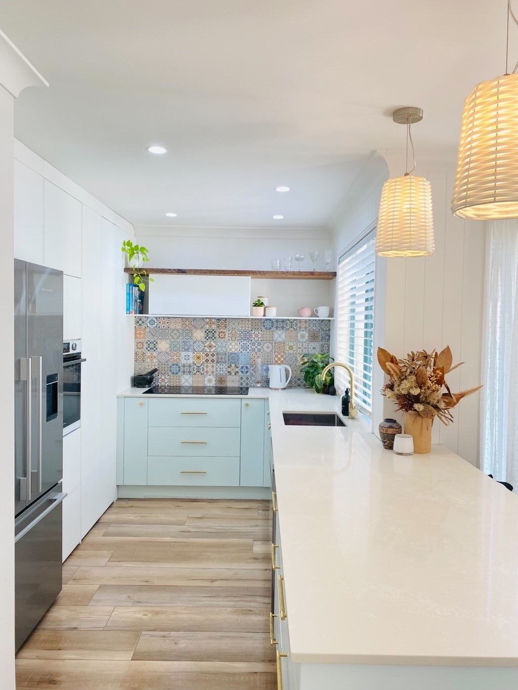 A Kitchen With White Cabinets , a Refrigerator , a Sink , and a Large Island — JPR Concepts in Burleigh Heads, QLD