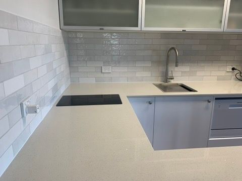 Modern White Kitchen with Gray Cabinets and Tiled Backsplash — JPR Concepts in Burleigh Heads, QLD