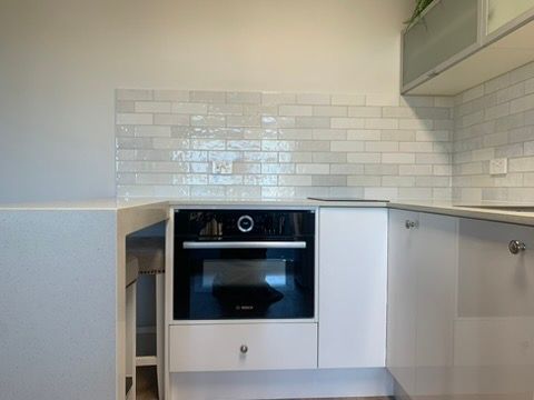 Modern Kitchen with White Cabinets and Tiled Backsplash — JPR Concepts in Burleigh Heads, QLD