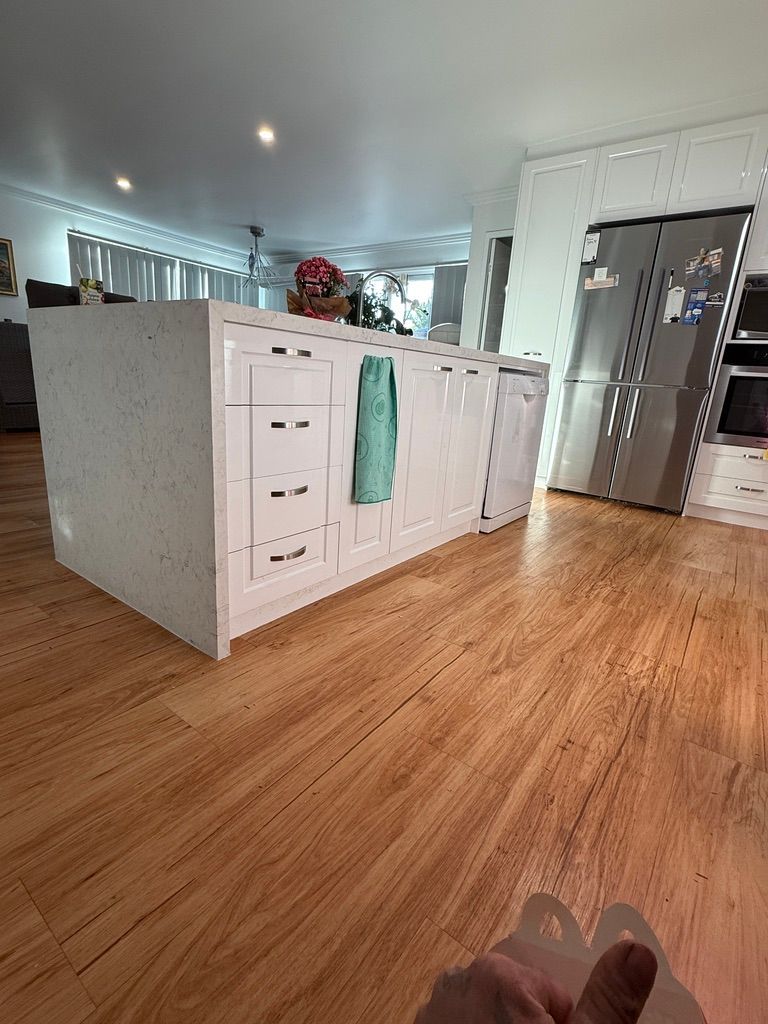 Modern Kitchen with White Cabinets and Warm Wood Floors — JPR Concepts in Burleigh Heads, QLD