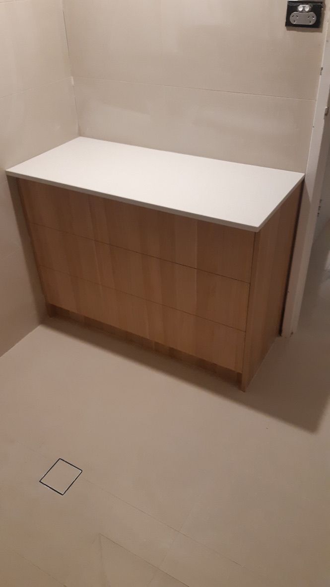 White Topped Wooden Cabinet Against a Beige Wall in A Bare Room with Tiled Floor — JPR Concepts in Burleigh Heads, QLD