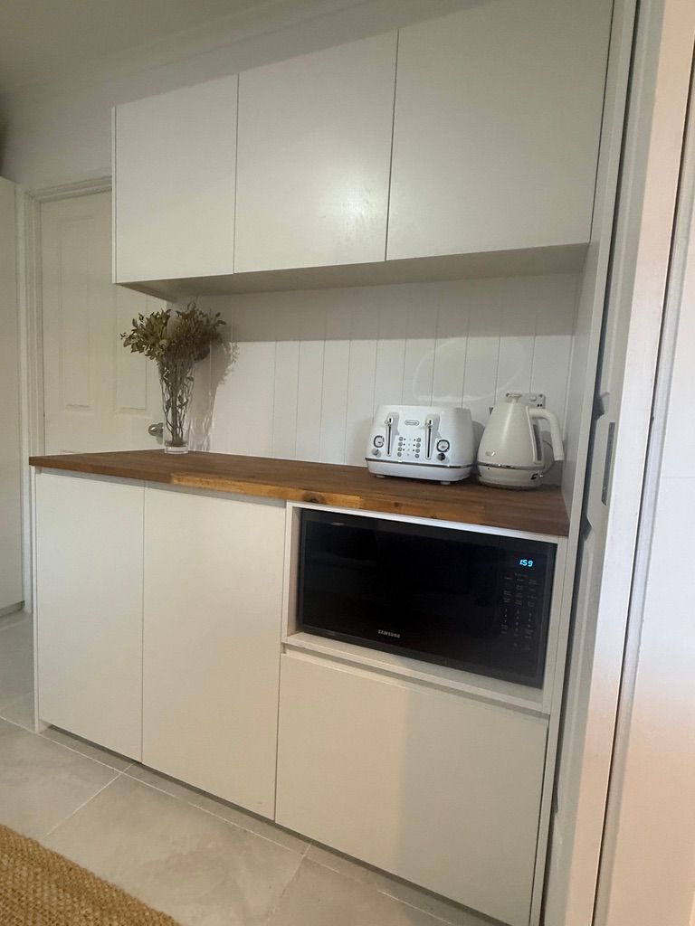 White Kitchen Cabinet with Wood Countertop and Built In Microwave Oven — JPR Concepts in Burleigh Heads, QLD