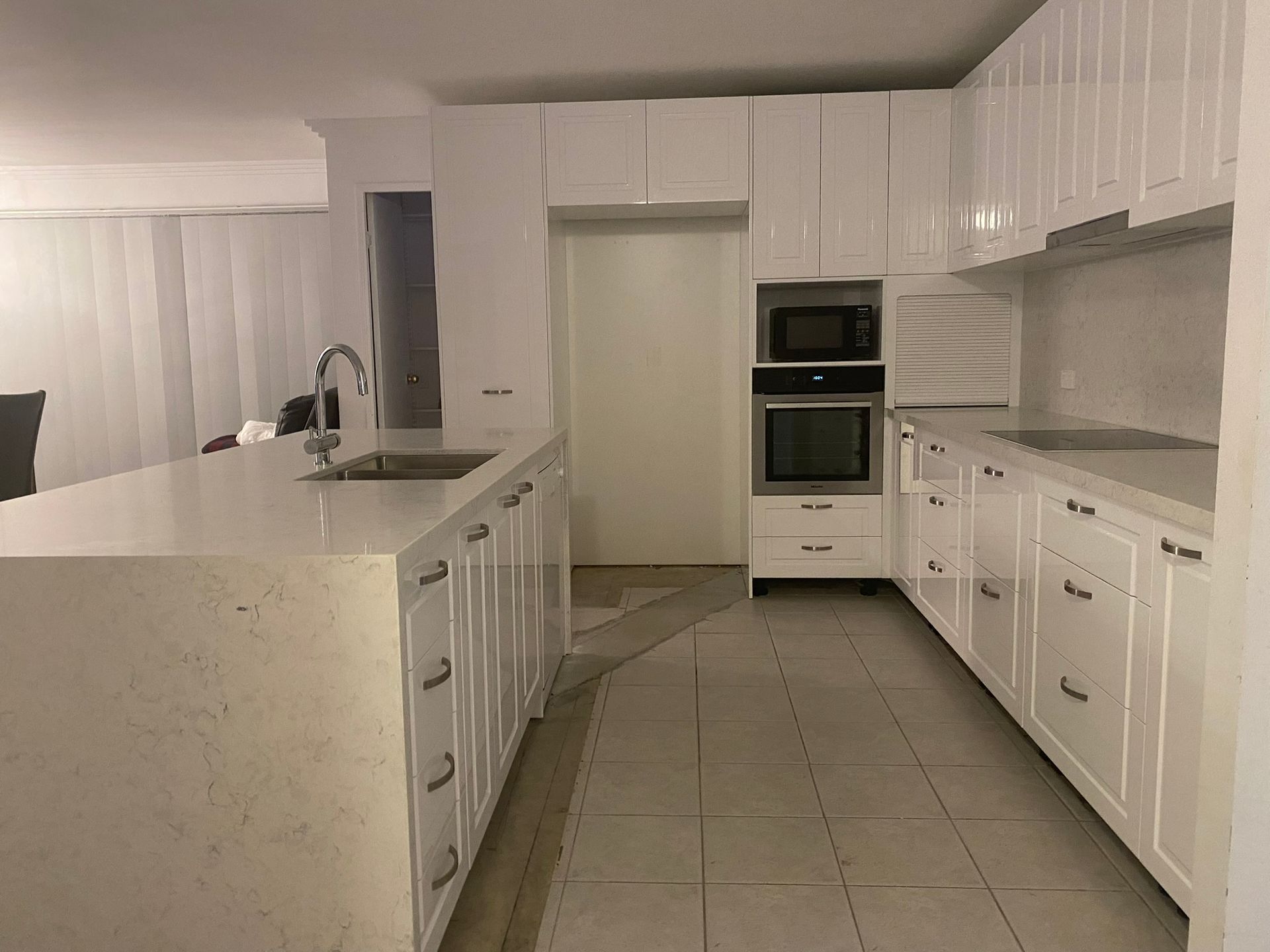 Modern White Kitchen with Island, Tiled Floor, Built In Oven, and Cabinets — JPR Concepts in Burleigh Heads, QLD