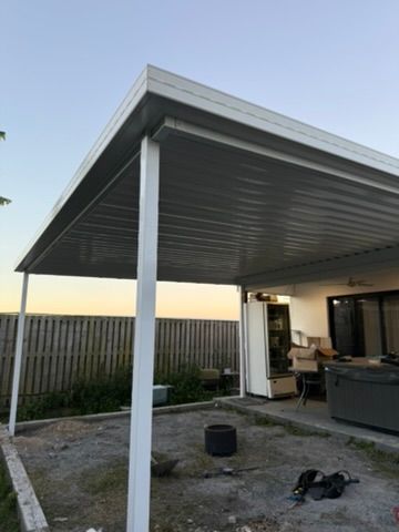 Covered Patio with White Posts, Outdoor Furniture, and A Fenced Yard at Sunset — JPR Concepts in Burleigh Heads, QLD