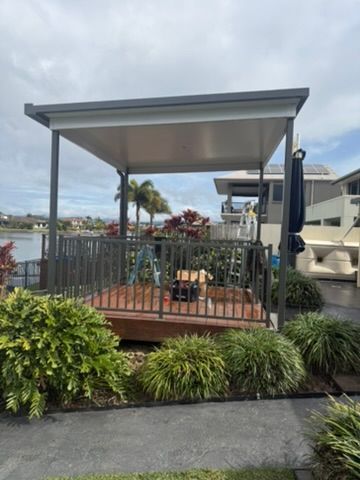 Small Covered Patio Deck with Railing and Potted Plants — JPR Concepts in Burleigh Heads, QLD