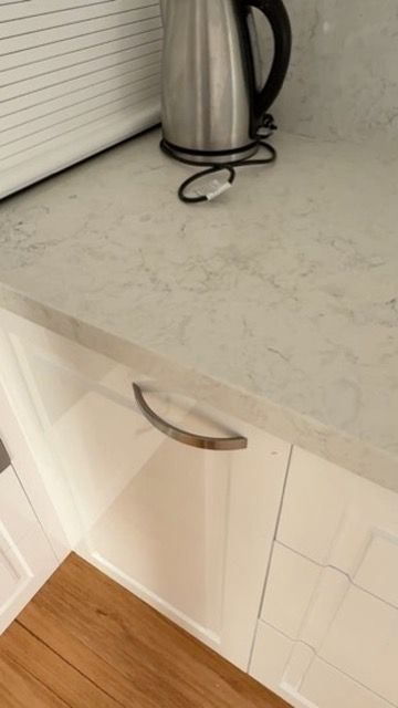 Stainless Steel Kettle on A Light Countertop Above a White Cabinet with A Curved Handle — JPR Concepts in Burleigh Heads, QLD