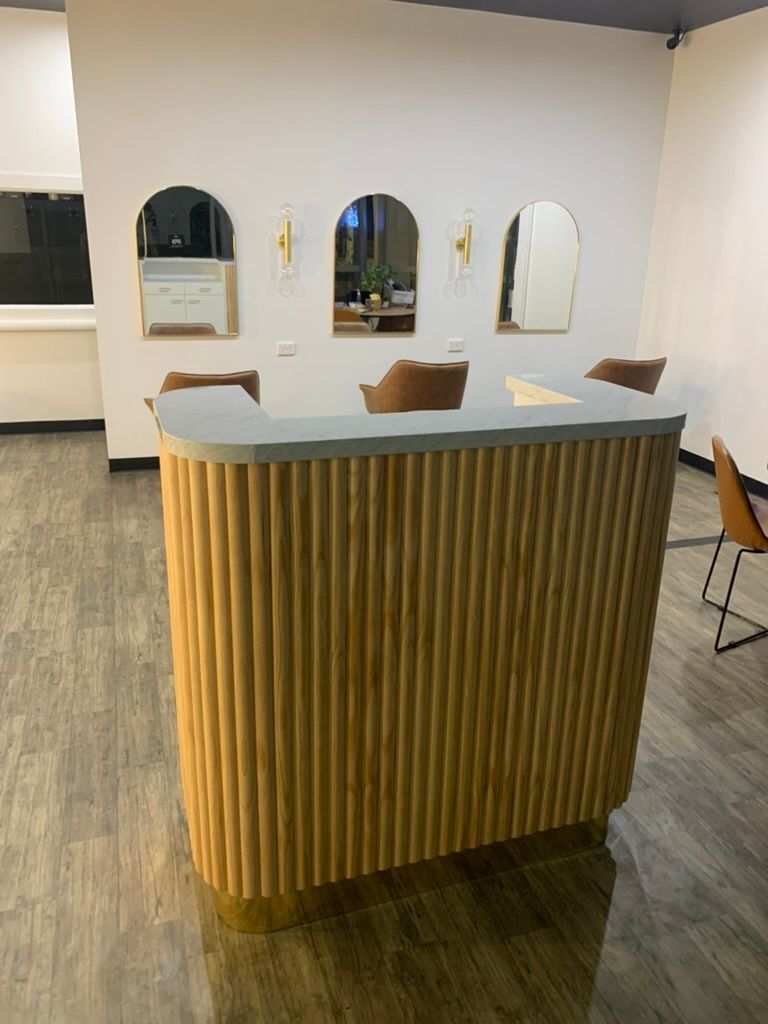 Modern Salon Reception Desk with Gold Ribbed Front and Arched Mirrors on A White Wall — JPR Concepts in Burleigh Heads, QLD
