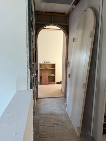 Narrow Hallway with An Open Doorway Leading to A Lit Room with Boxes and A Dresser — JPR Concepts in Burleigh Heads, QLD