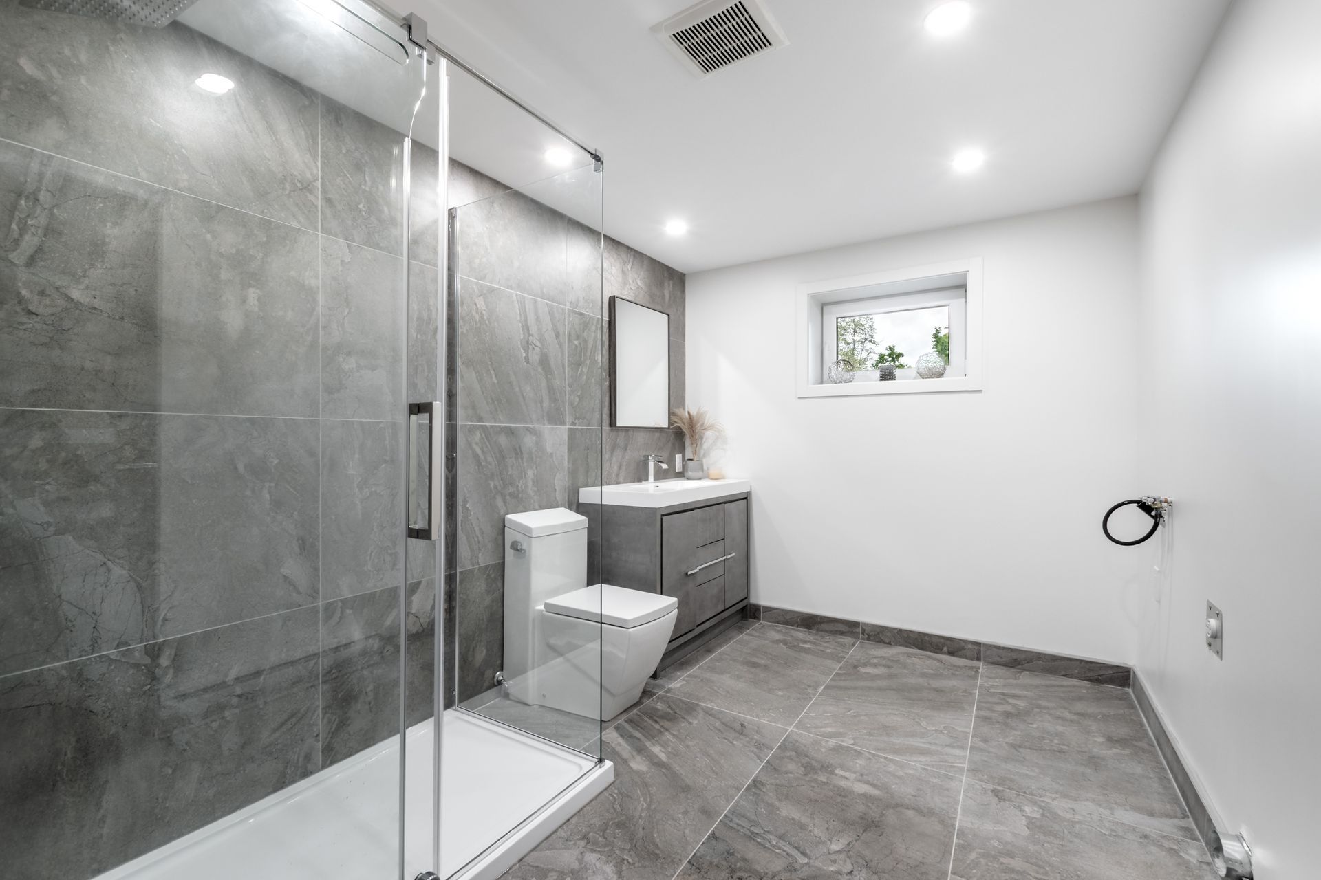 Modern Bathroom with Gray Tile, Glass Shower, Vanity, Toilet, and White Walls — JPR Concepts in Burleigh Heads, QLD
