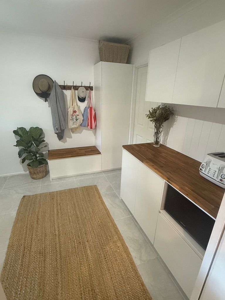 Bright White Hallway with Woven Rug and Wooden Countertop — JPR Concepts in Burleigh Heads, QLD